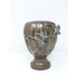 A 19th century Japanese bronze lobed urn decorated in relief with bamboo, orchid sprays and birds.