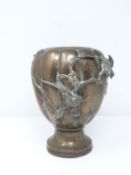 A 19th century Japanese bronze lobed urn decorated in relief with bamboo, orchid sprays and birds.