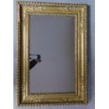 A 19th century wall mirror in floral, beaded and husk carved giltwood frame 97x67cm