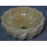 A carved and polished alabaster wash basin with a scalloped spiral design. H.5 W.42 D.42cm