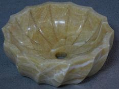 A carved and polished alabaster wash basin with a scalloped spiral design. H.5 W.42 D.42cm