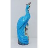 An antique Chinese turquoise glazed peacock perched on a pierced glazed aubergine base with white