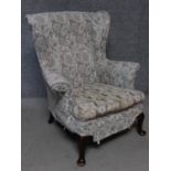 A vintage beech framed Parker Knoll wingback armchair. H.97cm