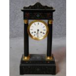 An antique French ebonised portico clock with tortoiseshell and brass inlaid detailing. White enamel