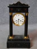 An antique French ebonised portico clock with tortoiseshell and brass inlaid detailing. White enamel