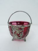 An antique silver plated sugar bowl with cranberry glass liner. Basket is pierced with a butterfly