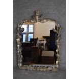 A gilt metal framed mantel mirror with scrolling foliate decoration. H.100x70cm