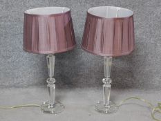 A pair of contemporary clear perspex table lamps with blush pleated shades. H.61cm