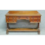 A William IV mahogany writing table with an arrangement of five drawers on reeded bun feet united by