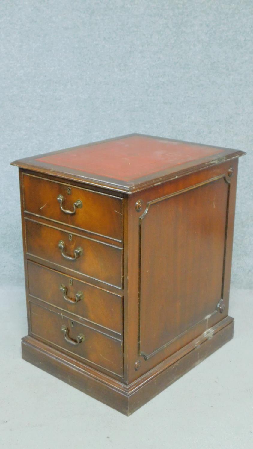 A Georgian style filing cabinet with inset tooled red leather top above two drawers on plinth