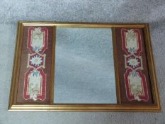 A gilt framed mirror with central plate flanked by stylised woollen tapestry panels. 69x49