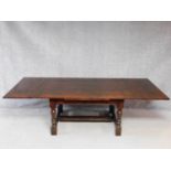 A Jacobean style oak draw leaf refectory style dining table on stretchered turning tapering