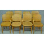 A set of eight contemporary bentwood dining chairs with caned backs and seats, to include two