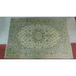 A Tabriz style rug with central double pendant medallion surrounded by repeating floral motifs on an