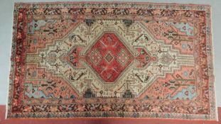 A Qashqai style rug with central pendant medallion set on a rouge field surrounded by repeating