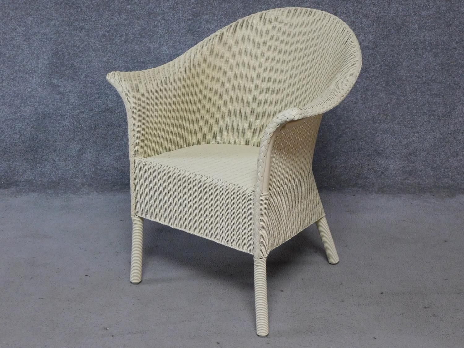 A vintage style Lloyd Loom conservatory armchair with makers label. H.82cm