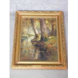 A gilt carved framed oil on canvas depicting a river in a forest. Jan Knikker signed alias Henk