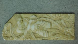 An antique Asian carved alabaster plaque of a lounging deity. 35x13cm