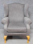 A Georgian style wing back armchair upholstered in pale grey velour on cabriole supports. H.108cm