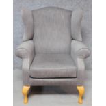 A Georgian style wing back armchair upholstered in pale grey velour on cabriole supports. H.108cm