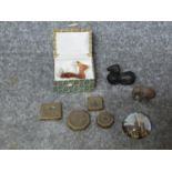 A collection of metal items and a carved carnelian deer. Including a bronze scroll weight in the