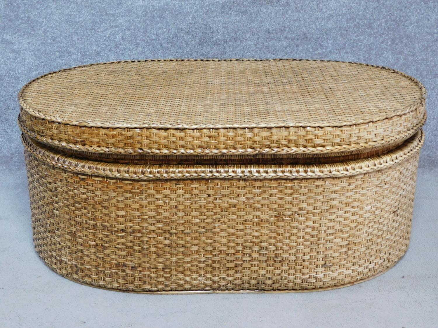 A wicker ottoman fitted with lift out tray by Oka. H.46 W.110 D.72cm