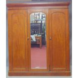 A Victorian mahogany wardrobe with arched panel doors enclosing two short over two long drawers