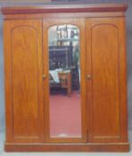 A Victorian mahogany wardrobe with arched panel doors enclosing two short over two long drawers