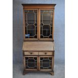 An Edwardian mahogany and inlaid bureau bookcase with astragal glazed upper section above fitted