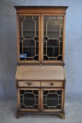 An Edwardian mahogany and inlaid bureau bookcase with astragal glazed upper section above fitted