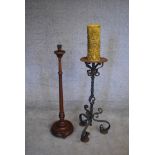 A wrought iron floor standing pricket candlestick and a turned wooden example. H.100cm