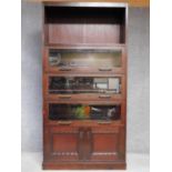 An early 20th century oak bookcase with open upper section above three bevelled glazed sections