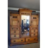 A late 19th century carved ash triple section compactum wardrobe in the Arts and Craft's style
