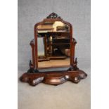 A Victorian mahogany swing framed toilet mirror on shaped platform base fitted with jewellery