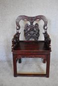 A Chinese carved hardwood open armchair on square section stretchered supports. H.100x57cm
