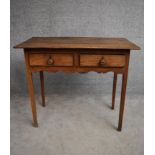 An antique country elm two drawer side table with shaped frieze on square section supports. H.