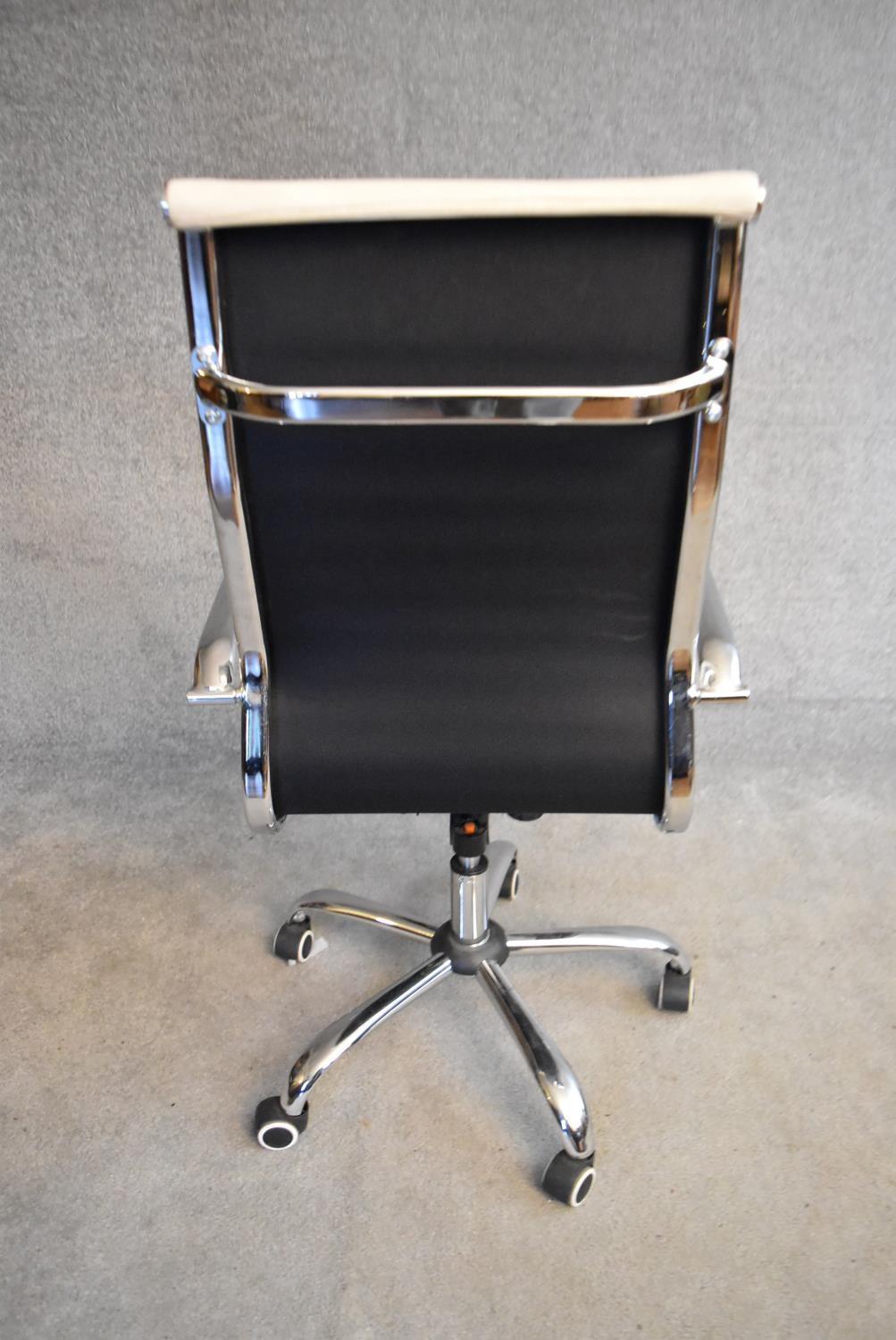 A Charles Eames style swivel office armchair in cream vinyl upholstery. H.110x56cm - Image 3 of 5