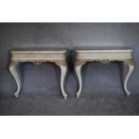 A pair of mid 20th century white painted and rococo carved console tables with inset mirrored tops