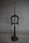 A 19th century adjustable oak fire screen on naturalistically carved base. H.157cm