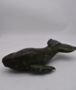 A carved soapstone sculpture of a whale. Signed underneath. L.40cm