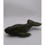 A carved soapstone sculpture of a whale. Signed underneath. L.40cm