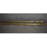 Two brass curtain poles and rings with shaped reeded finials. Longest L.174/Shortest L.167cm