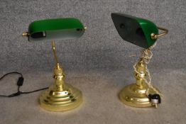 A pair of banker's desk lamps with green glass shades on brass bases. H.40cm