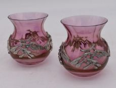 A pair of cranberry glass vases with allover white metal sycamore seed mounts. H.10cm