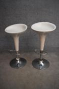 A pair of moulded adjustable high stools on chrome platform bases. H.85cm