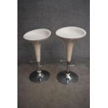 A pair of moulded adjustable high stools on chrome platform bases. H.85cm