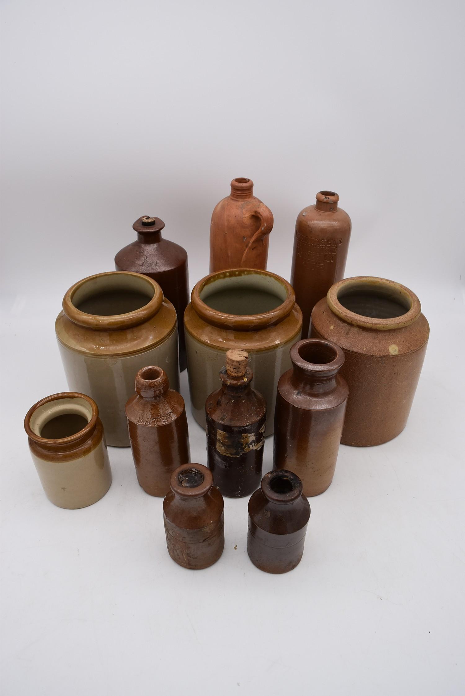 A collection of antique earthenware glazed bottles and jars, some with impressed makers marks. H.