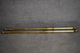 A pair of fluted brass curtain poles and rings with acorn finials. L.170cm