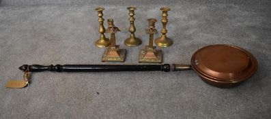 A pair of brass candlesticks, three others and a copper warming pan. H.22cm (candlesticks) H.