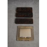 A set of three Eastern carved hardwood coat hangers and a metal framed mirror with candle sconces.